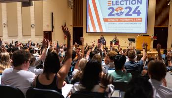 Students in the "Election 2024" Politics class raise their hands in response to a question posed by professors Jennifer Lawless and Mary Kate Cary.