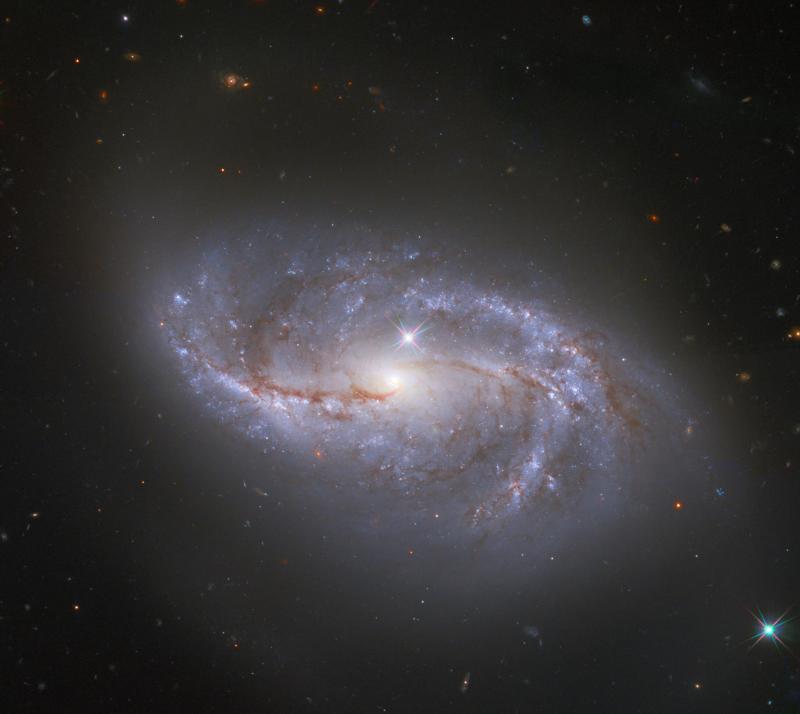 Looking deep into the universe, the NASA/ESA Hubble Space Telescope catches a passing glimpse of the numerous arm-like structures that sweep around this barred spiral galaxy, known as NGC 2608.