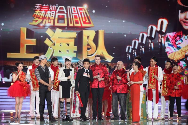 College alums Habib and Nierow, in red satin tops, join the cast of China’s “Clash of the Choirs” with pop star Momo Wu, fifth from the left.