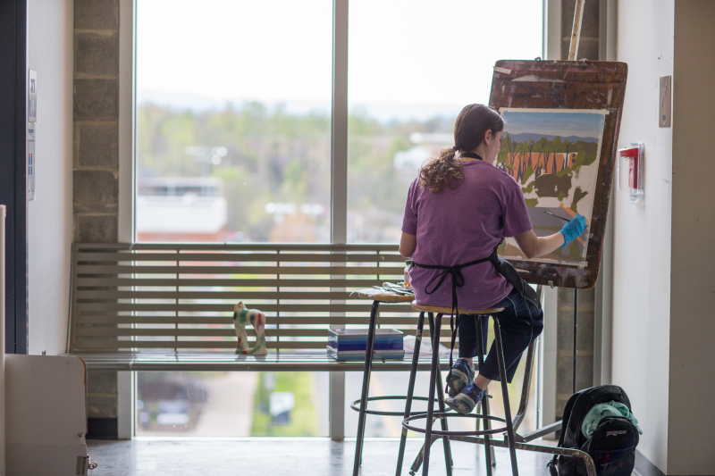 UVA student painting in Ruffin Hall 