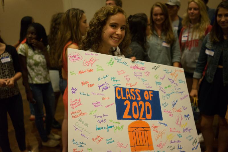 Student holding sign with signatures of Class of 2020 First-Year Forums Students