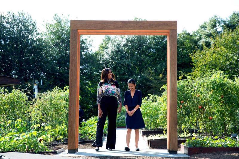First lady Michelle Obama stands with Tammy Nguyen, a student participating in the first lady’s “Let’s Move!” initiative, beneath a new arbor designed by UVA students for the White House Kitchen Garden. 