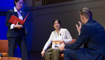 Tech journalist Karen Hao listens to a point made by a UVA faculty member while the panel moderator stands nearby listening to their conversation.