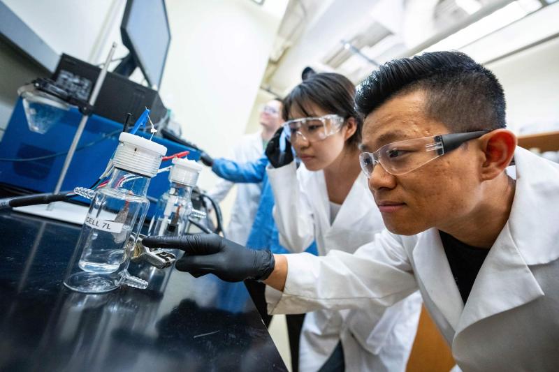 Students Liyue Zhang and Shen-Wei Yu, foreground, lean in for a closer look in a UVA lab aiming to make hydrogen energy a viable alternative.