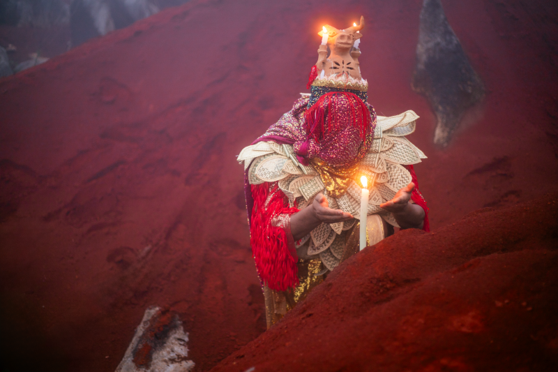 Artistic image of woman with head bowed holding a lit candle.